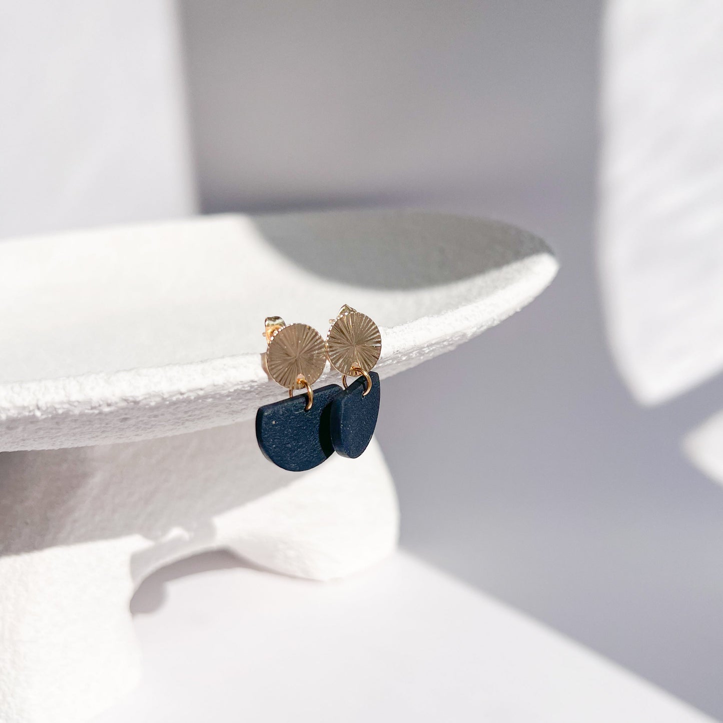 Handgefertigte Ohrringe mit goldfarbenem Sonnenmotiv und schwarzem Halbkreis-Anhänger, antiallergischer Edelstahlstecker.